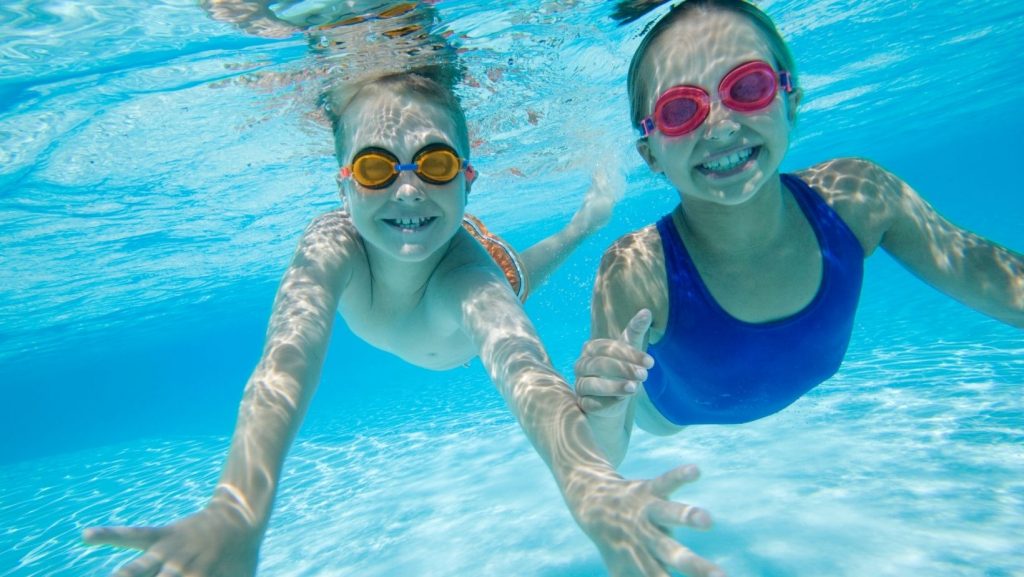 a boy and girl swimming underwater