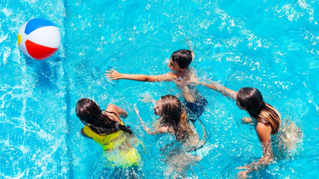 kids playing in a pool with a beach ball